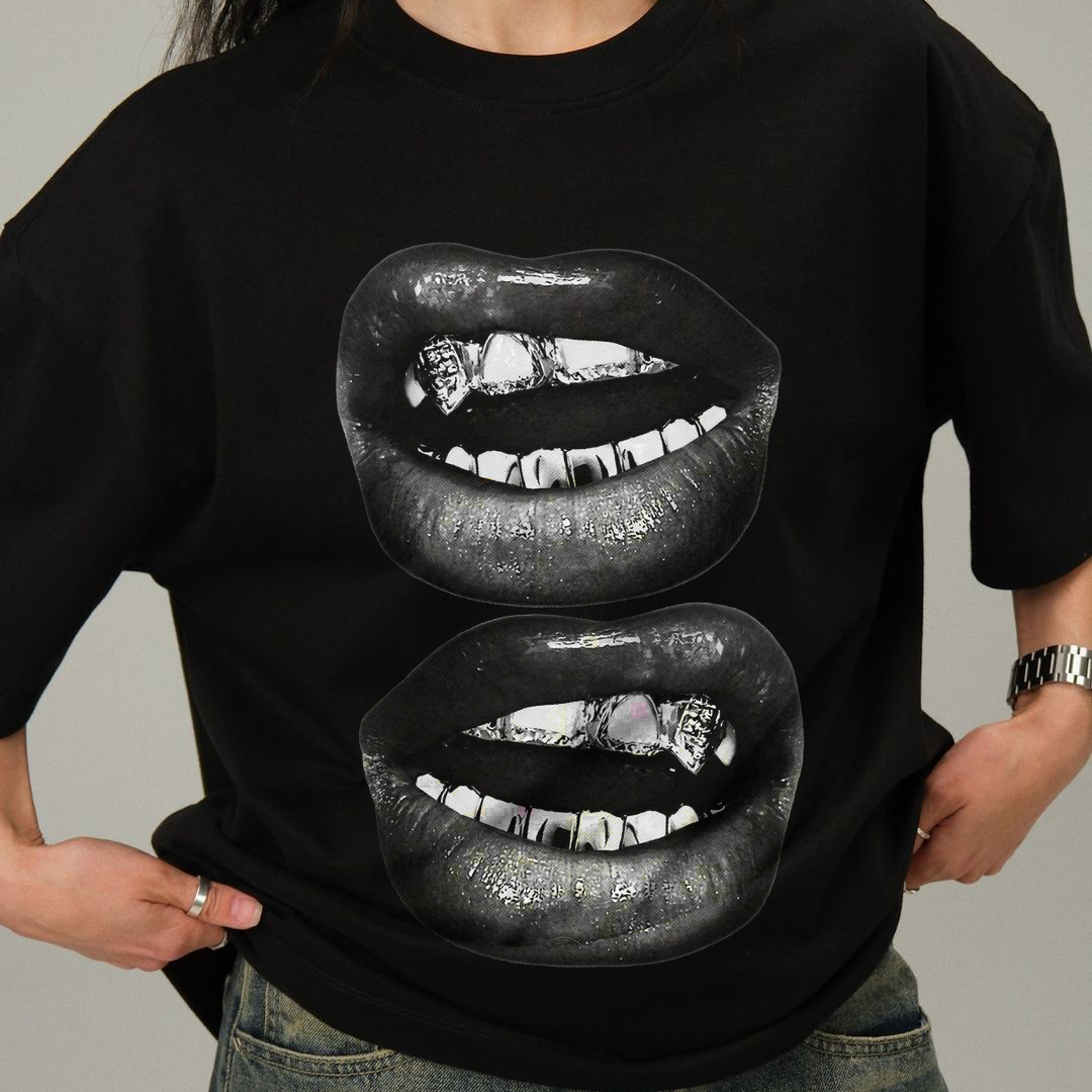 Person wearing a black t-shirt with graphic of lips on a plain background
