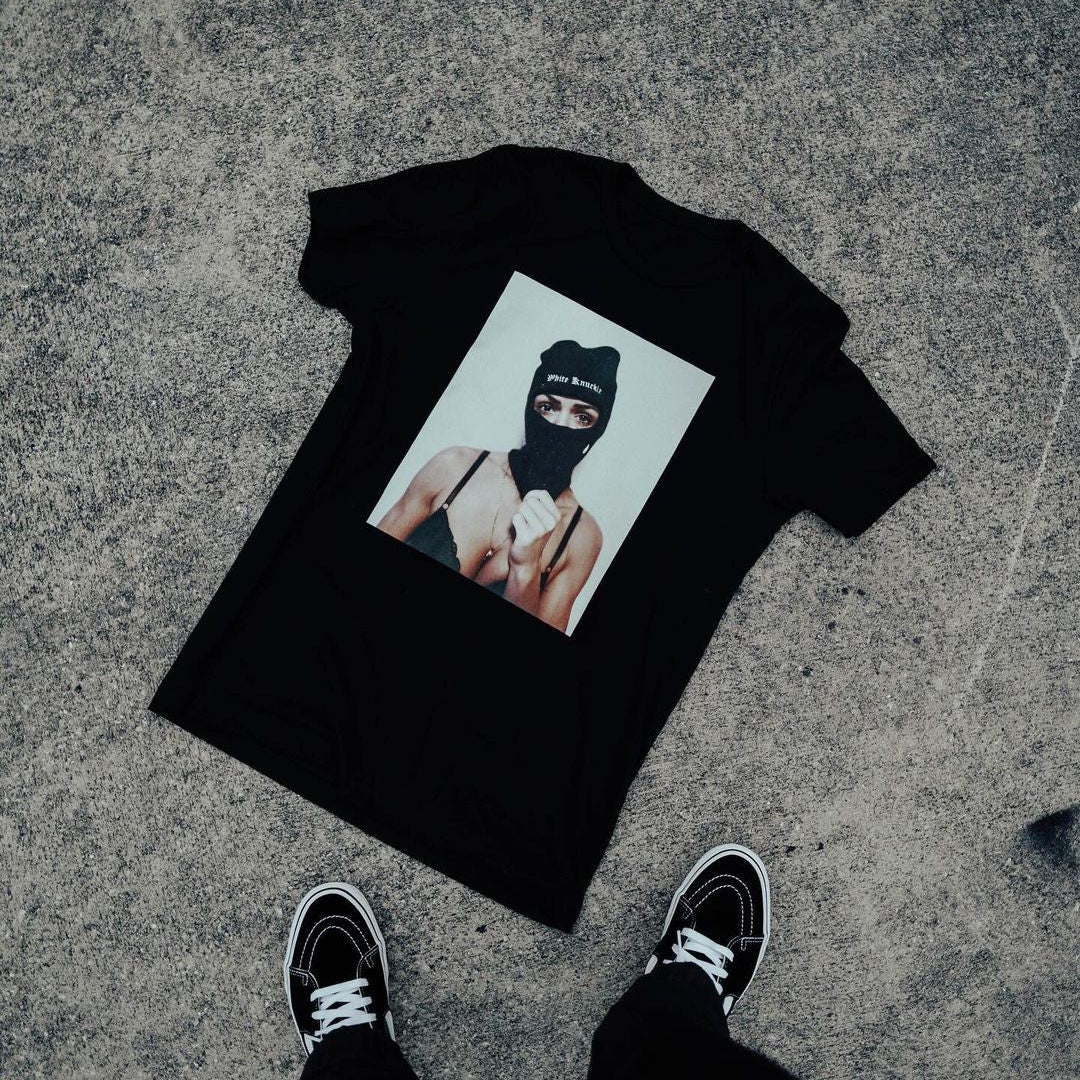 Black t-shirt with graphic design on a concrete surface